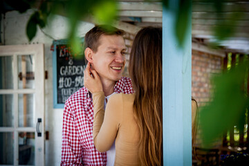 The guy with a girl hugs near a wooden house