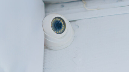 indoor security camera on a white wall under the ceiling
