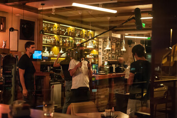 Behind scenes. Film crew team filming movie scene in restaurant