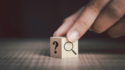 Hand flip magnifying glass and question mark sign icon in wooden cube. Problems and root cause...