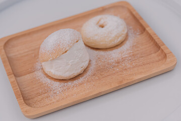 Soft buns filled with creamy are placed in a wooden dish sprinkled with icing sugar.Homemade confectionery,bakery business,baking school or cafe concept,high-energy snacks containing starch and sugar.