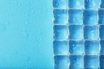 Many frosty and refreshing ice cubes with drops on a blue backgroun