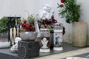 Moderne Friedhofsgestaltung mit Gedenkkerzen und Engeln in Weiß und Silber, geschmückte Urnengräber, Gedenkstätten, Tod, Grabschmuck, Trauer, Allerheiligen