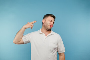 The man in the white T-shirt shot himself in the head with a finger and grimaced. Adult man commits...