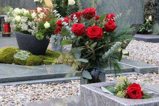 Anspruchsvolle Grabgestaltung mit weißen und roten Rosen an einem katholischen Friedhof in Österreich zu Allerheiligen, Tod, Trauer, Bestattung, Friedhof, Grabschmuck, Gedenken