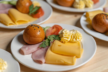 Morning breakfast, ham, cheese, bun and butter. Dishes are displayed in the restaurant and ready to be served. Clouse-up