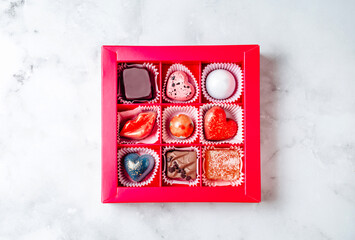 A set of chocolates in a red flatlay gift box. Creative handmade sweets