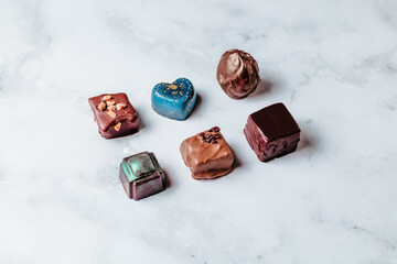 A set of handmade chocolates. Creative sweets made of natural chocolate with the addition of nuts. Minimalistic creative design of desserts