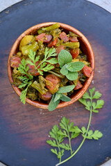closeup the fried peas,brooklyn ,red carrot, with mint and coriander leaves vegetable made i the wooden bowl over out of focus wooden brown background.
