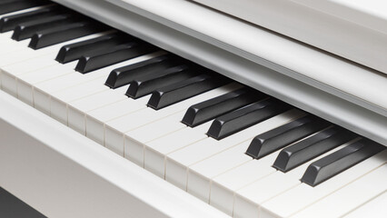 Naklejka premium Black and white piano keys closeup with light gradient.