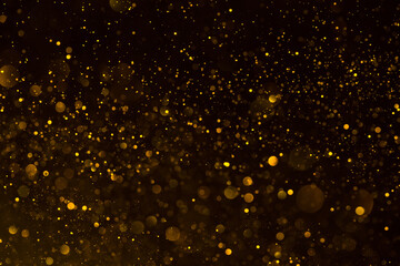 Abstract golden glitter dark bokeh background of shiny lights