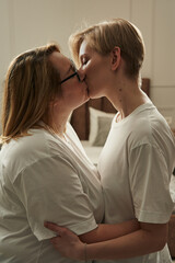 lesbian couple in white t-shirts gently kiss close-up