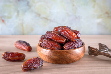 Bowl of dates fruit on wooden background