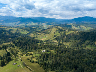 Green mountains of Ukrainian Carpathians in summer. Coniferous trees on the slopes. Aerial drone view.