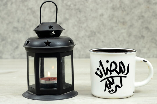 Ornamental Arabic lantern with burning candle glowing and cup of coffee on wood table. Festive greeting card. Invitation for Muslim holy month - Powered by Adobe