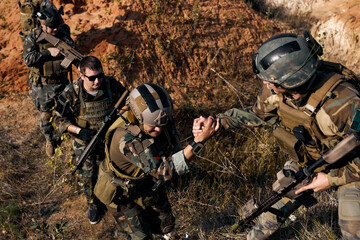 caucasian european men help each other during the military operation while climbing on mountain,...