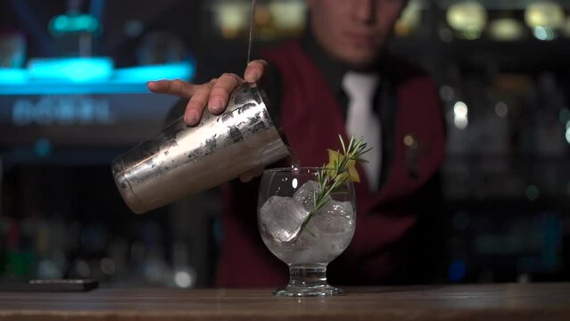 Bartender serving a fruit cocktail with ice