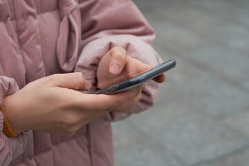 Detail of hand typing a message on the smartphone. Close up.  Comunication concept.