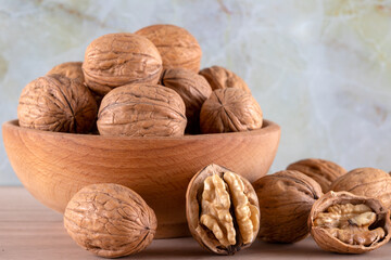 Walnut kernels and whole walnuts on wooden background,front view