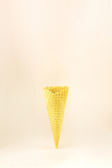 Empty sugar waffle cone on beige pastel background.