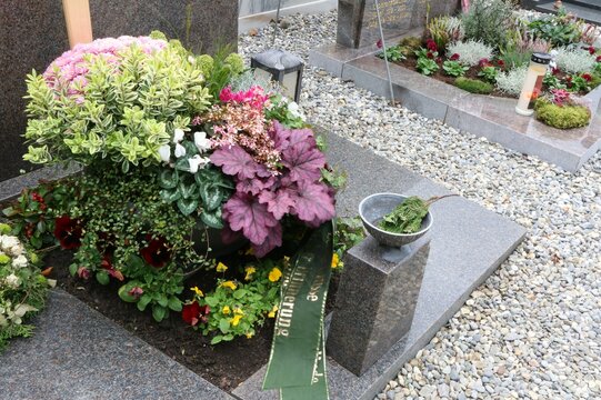 Herbstliche Grabgestaltung an einem katholischen Friedhof in Österreich, Herbstbepflanzung auf Familiengräbern