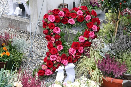 Ein Herz aus Rosen an einem Grab in Österreich, Floristik, Beisetzung, Friedhofschmuck, Blumenschmuck, Trauer, Tod, Allerheiligen