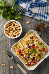 Salad with rice, chicken, peanuts and vegetables. Top view.