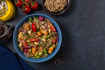 Salad with quinoa, avocado and chicken. Top view. Served in a blue bowl.