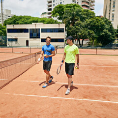 Obraz premium Lets catch up after the game. Shot of two tennis players talking on the court.