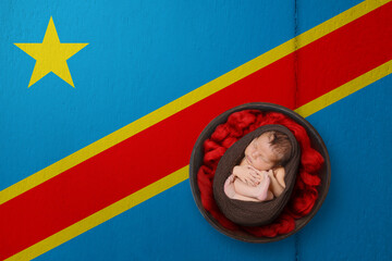 Newborn portrait on background in color of national flag. Patriotic photography concept. Democratic Republic of the Congo