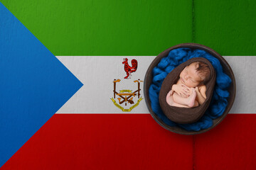 Newborn portrait on background in color of national flag. Patriotic photography concept. Equatorial Guinea