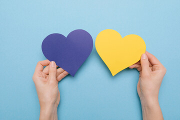 There is no war. blue and yellow heart made of paper in female hands 