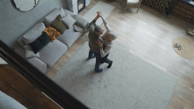 Elderly gray-haired couple after so many years of marriage still loves to dance