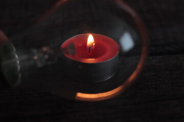 Bombilla con el reflejo de una vela encendida en la oscuridad