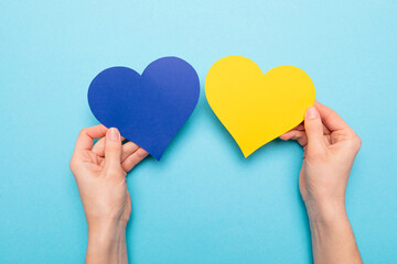 There is no war. blue and yellow heart made of paper in female hands 