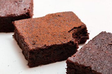 Slices of brownie dessert on a light background
