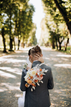 Beautiful wedding bouquet in rustic style in the hands of the bride in the park
