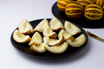 Vietnamese melon close up. Whole and cut gourmet miniature tropical fruit and knife. Selective focus