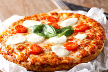 Fresh delicious pizza baked pizza with tomato, mozzarella cheese and fresh basil.