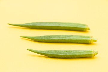 three Lady Finger or okra isolated on yellow background