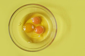 Three raw eggs on a yellow background with a space to copy. Healthy food. Fashionable color. High quality photo