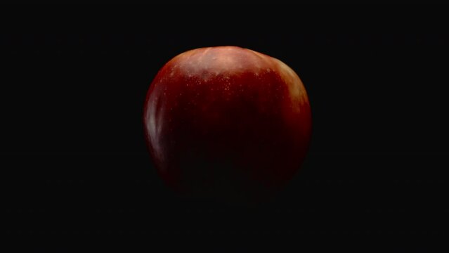 Close-up, a red apple rotates on an axis on a black background
