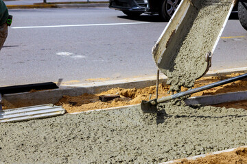 Workers concrete mixer with pouring cement during to residential on sidewalk