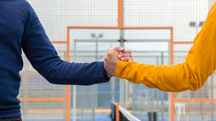 Male padel players handshake after win a padel match in blue paddel court indoor - obrazy, fototapety, plakaty