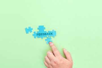 Businessman connecting puzzle pieces with the word Feedback