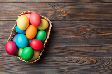 Multi colors Easter eggs in the woven basket on colored background . Pastel color Easter eggs. holiday concept with copy space