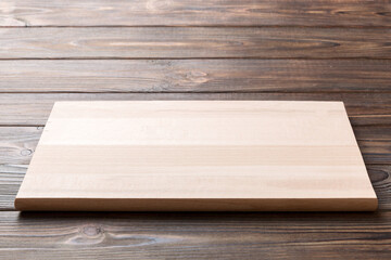 Perspective view of wooden cutting board on wooden background. Empty space for your design