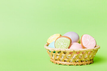 Obraz na płótnie Canvas Colorful easter cookies in basket with Multi colors Easter eggs on colored background . Pastel color Easter eggs. holiday concept with copy space