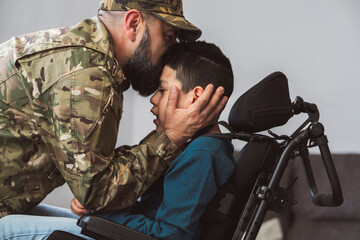 A soldier father kisses his disabled son in a wheelchair before going to war - dysfunctional family...