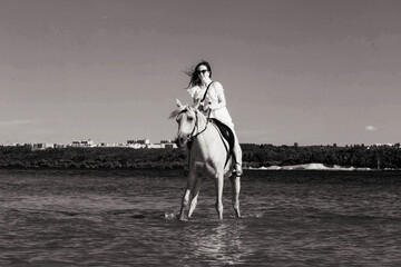 girl on a horse in the river on a sunny day